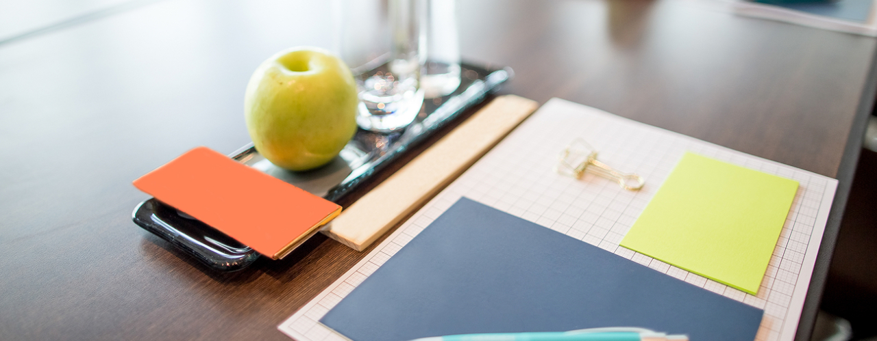Imagen de documentos junto a una manzana y agua
