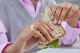 Mano de mujer sujetanto un sanwich
