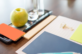 Imagen de documentos junto a una manzana y agua